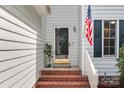Charming entryway with brick steps, American flag, and a welcoming glass door at 9904 Brigstock Ct, Charlotte, NC 28269