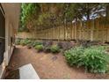 Landscaped backyard with a wooden fence, decorative plants and greenery at 110 Whitehall Dr, Mooresville, NC 28117