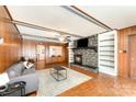 Cozy living room featuring a stone fireplace and wood-paneled walls at 1107 Fairfield Dr, Gastonia, NC 28054