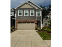 Inviting townhome with a two-car garage, showcasing brick and gray siding at 12301 Gambrell Dr, Charlotte, NC 28278