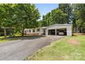 Single-story home with an open garage and a spacious paved driveway at 125 Brasington Ln, Mooresville, NC 28115