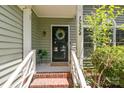 Close-up of the front door with brick steps, a wreath, and the house number at 12524 Angel Oak Dr, Huntersville, NC 28078