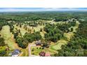 Breathtaking aerial view of a modern home nestled in a golf course community surrounded by lush trees at 130 Broken Arrow Dr, Statesville, NC 28677