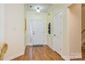 View of the foyer with wood floors, white trim, front door and coat closet at 13402 Mccoy Rd, Huntersville, NC 28078
