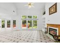 Bright living room with fireplace, tiled floors, built-in shelves, and large windows overlooking the backyard at 13832 Queenswater Ln, Charlotte, NC 28273