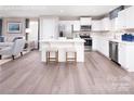 Modern kitchen with white cabinets, stainless steel appliances, an island with seating, and a view into the living area at 147 Commerce Blvd # 0003, Lancaster, SC 29720
