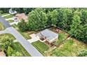 Aerial view of the home, fenced-in backyard with a playset, and bordered by mature trees at 1616 Indian Springs Nw Dr, Conover, NC 28613