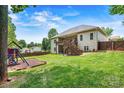 Beautiful fenced backyard with lush grass, a playset, covered deck, and wooded views at 1616 Indian Springs Nw Dr, Conover, NC 28613