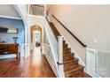 Elegant foyer with hardwood floors, staircase, and wainscoting, creating a grand entrance at 18732 Coachmans Trce, Cornelius, NC 28031