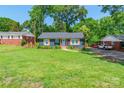 Well maintained home with expansive lawn, blue painted brick, and new gray roof at 2116 Eastway Dr, Charlotte, NC 28205