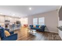 Inviting living room with hardwood floors, a comfortable sofa, and views of the adjacent kitchen at 2116 Morgan Hills Dr, Albemarle, NC 28001