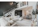 Bright living area featuring modern staircase, neutral furniture, an open floor plan and wood floors at 2514 Marshall Pl, Charlotte, NC 28203