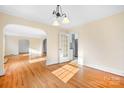 Open-concept dining room with hardwood floors, an elegant chandelier, and natural light at 3515 Back Creek Church Rd, Charlotte, NC 28213