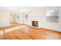 Sunlit living room with hardwood floors, decorative fireplace, and large windows at 3515 Back Creek Church Rd, Charlotte, NC 28213