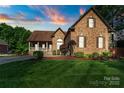 Charming brick home with lush front lawn and manicured landscaping at 3831 Riceland Pl, Charlotte, NC 28216