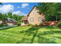Well-maintained home featuring lush green lawn, mature trees, and a long driveway at 3831 Riceland Pl, Charlotte, NC 28216