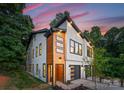 Stylish home featuring a modern design with wood and white accents and a well-maintained lawn at 4117 Sarah Dr, Charlotte, NC 28217