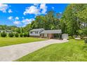 Well-maintained home with a long driveway, carport, and storage shed, surrounded by mature trees and a green lawn at 416 Donna Ave, Gastonia, NC 28052