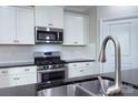 Well-equipped kitchen with white cabinets, stainless steel appliances, and a stylish faucet at 4333 Legacy Dr, Denver, NC 28037