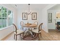 Bright dining room area featuring modern chandelier lighting and updated flooring at 5229 Tarrywood Ln, Charlotte, NC 28205