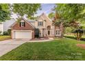 Charming two-story brick home with tan siding, manicured lawn, and inviting front entrance at 5707 Fairvista Dr, Charlotte, NC 28269