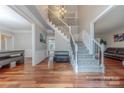 Grand foyer featuring hardwood floors, staircase with wrought iron spindles, and ample natural light at 5707 Fairvista Dr, Charlotte, NC 28269