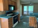 A kitchen features wood cabinets, an oven, and a microwave with views to the outdoor patio at 5727 Dockside Dr, Charlotte, NC 28227