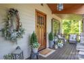 Cozy front porch features a wooden door, comfortable seating and seasonal decorations at 5888 Wood Duck Way, Catawba, NC 28609