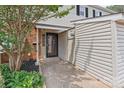 Charming entryway featuring a brick accent wall and lush landscaping around the doorway at 5949 Quail Hollow Rd # E, Charlotte, NC 28210