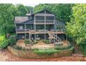 Multi-level decks and patio create an inviting outdoor space, surrounded by lush greenery and a brick retaining wall at 7221 High Point Ct, Charlotte, NC 28278