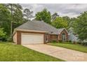 Side view of brick home showing the lawn, driveway, and attached two-car garage at 9137 Brightleaf Pl, Charlotte, NC 28269