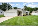 A cozy home with a two-car garage, a small porch with furniture, and a front lawn at 9319 Chislehurst Rd, Mint Hill, NC 28227