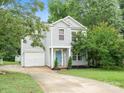 Charming two-story home featuring light blue siding, a blue front door, and a well-maintained front yard at 1003 Snake River Ct, Monroe, NC 28110