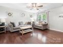 Cozy living room with hardwood floors, comfortable seating, a ceiling fan, and natural light from the window at 1003 Snake River Ct, Monroe, NC 28110