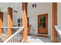 Inviting front porch features wooden columns, rocking chairs, a 'Welcome' mat, and a charming wood front door at 1004 E Sandy Ridge Rd, Monroe, NC 28112
