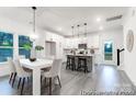 Open-concept dining area with modern table, chairs, and kitchen with stainless steel appliances in background at 10339 Lakeshore Dr # 85, Lancaster, SC 29720