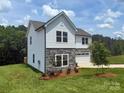 Attractive two-story home featuring stone accents, a manicured lawn, and mature trees at 10339 Lakeshore Dr # 85, Lancaster, SC 29720