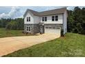 Beautiful new construction home with stone facade, attached garage, and a fresh, green lawn at 10339 Lakeshore Dr # 85, Lancaster, SC 29720
