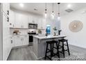 Well-lit kitchen with white cabinets, stainless steel appliances, island, and modern pendant lights at 10339 Lakeshore Dr # 85, Lancaster, SC 29720
