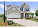 Attractive two-story home featuring a stone facade, blue shutters, and a spacious two-car garage at 106 Tuppy Ct, Statesville, NC 28625