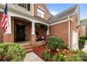 Inviting covered front porch with seating area, plants, and a beautifully landscaped garden at 10919 Valley Spring Dr, Charlotte, NC 28277