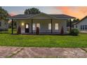 Charming white bungalow featuring a covered porch, dark-framed windows, and a lush green lawn at 113 Woodside Ave, Gastonia, NC 28054