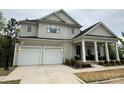 Lovely two-story home boasts a two-car garage and charming front porch with decorative columns at 11404 James Coy Rd, Davidson, NC 28036