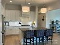 Bright kitchen featuring stainless steel appliances, a central island with chairs, and modern pendant lighting at 11404 James Coy Rd, Davidson, NC 28036