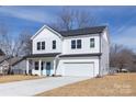 Charming two-story home with a bright blue door, two-car garage, and fresh landscaping at 118 Durham Rd, Stanley, NC 28164