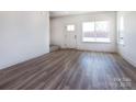 Bright living room featuring sleek wood floors, a large window, and a neutral color palette at 118 Durham Rd, Stanley, NC 28164
