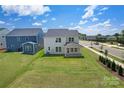 Expansive backyard features a well-maintained lawn, a covered patio, and views of neighboring homes and streets at 12009 Grinstead Ln # 303, Charlotte, NC 28278