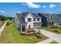 Beautiful two-story home with lush green lawn, showcasing the side yard and inviting front porch at 12009 Grinstead Ln # 303, Charlotte, NC 28278