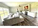 Bright living room with a large sectional sofa, fireplace, and a view of the front yard at 1238 Shinnville Rd, Cleveland, NC 27013