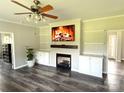 Cozy living room features a fireplace with built-ins, ceiling fan, and modern flooring at 1238 Shinnville Rd, Cleveland, NC 27013